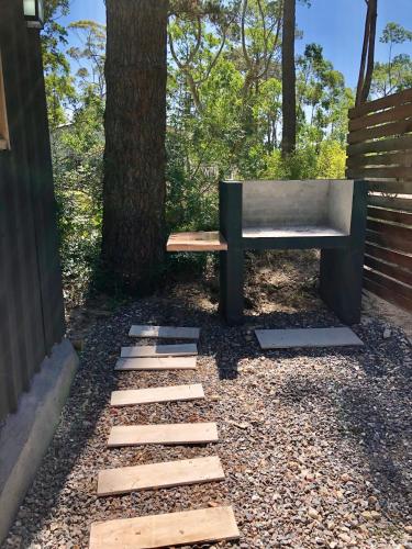 a bench sitting next to a tree next to a tree at Marittimo Cabañas in José Ignacio