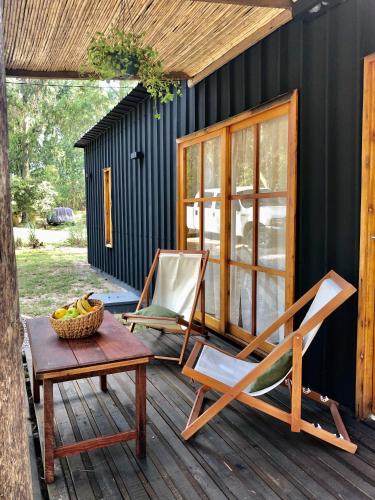 two chairs and a table on a deck at Marittimo Cabañas in José Ignacio