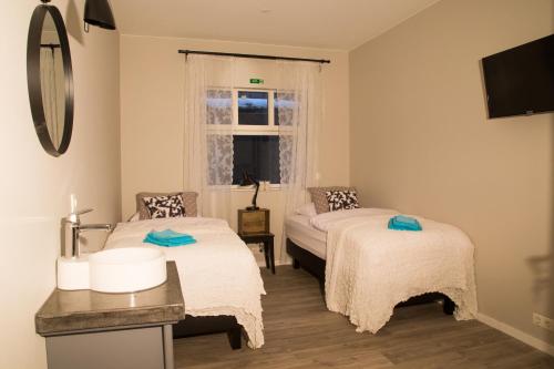 um pequeno quarto com 2 camas e uma janela em Varmi Guesthouse Apartments & rooms em Hveragerði