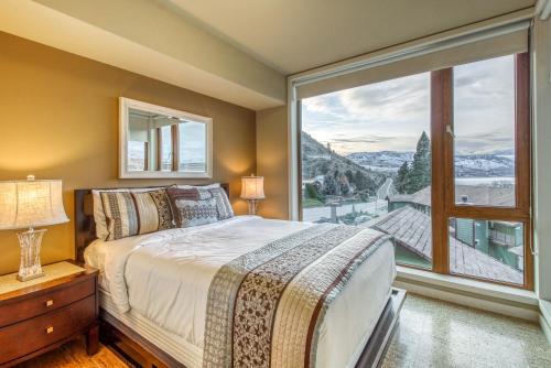 a bedroom with a bed and a large window at Chelan Resort Suites: Water Sunset (#303) in Chelan
