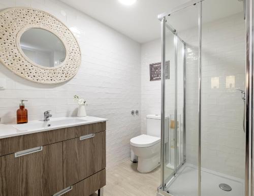 a bathroom with a toilet and a sink and a shower at Fisherman's Inn Loft in Montijo