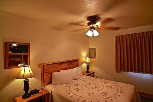 a bedroom with a bed with a ceiling fan at Yellowstone Village Inn and Suites in Gardiner