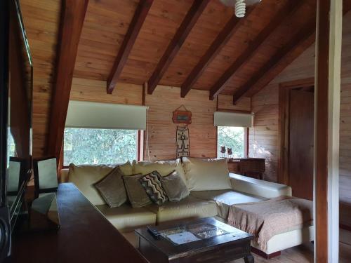 uma sala de estar com um sofá e duas janelas em Cabaña Modern Family em Villa La Angostura