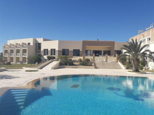 ein großer blauer Swimmingpool vor einem Gebäude in der Unterkunft Sufetula Hotel in Sbeitla