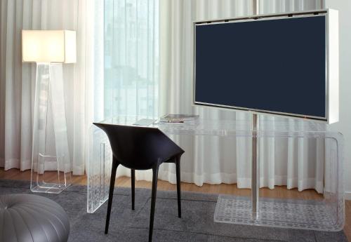 a glass table with a chair and a television on it at Mondrian Los Angeles in Los Angeles