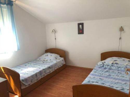 a bedroom with two beds and a window at Lili Murter in Murter