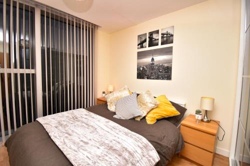 ein Schlafzimmer mit einem Bett und einem großen Fenster in der Unterkunft The Hub - Spacious, bright and modern with free parking in Milton Keynes