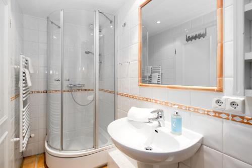 a white bathroom with a shower and a sink at Sylt Island House in Westerland