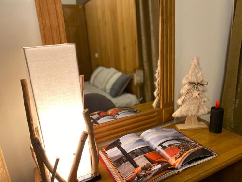a desk with a mirror and a book and a lamp at Pirin Golf and Spa Luxury Chalet in Bansko