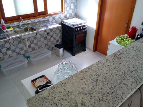 a kitchen with a counter with a sink and a stove at GREEN HOUSE in Pipa