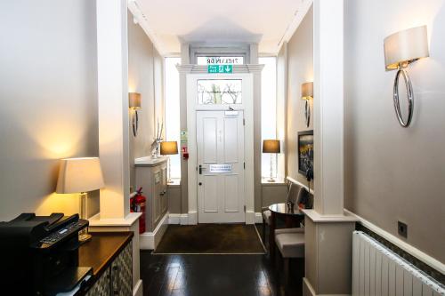 a hallway with a white door with a sign on it at Embassy Apartments in Glasgow