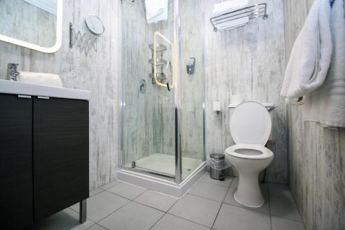 a bathroom with a toilet and a glass shower at Embassy Apartments in Glasgow