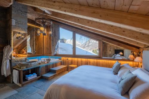 a bedroom with a bed and a bathroom with a sink at Park Chalet Village in Livigno