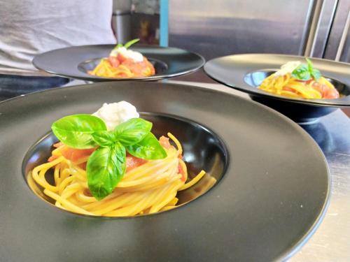 a plate of pasta with a green garnishment on it at Hotel Le Ceramiche in Montalto Uffugo