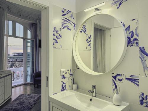 un bagno con pareti bianche e blu e uno specchio di Guesthouse Tricana de Aveiro ad Aveiro