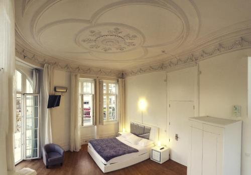 a bedroom with a bed and a ceiling at Guesthouse Tricana de Aveiro in Aveiro
