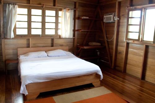 1 dormitorio con 1 cama en una habitación de madera en M&M's Residencias, en Bocas Town