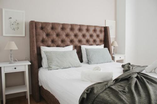 a bedroom with a large bed with a padded headboard at Be My Guest Athens in Athens