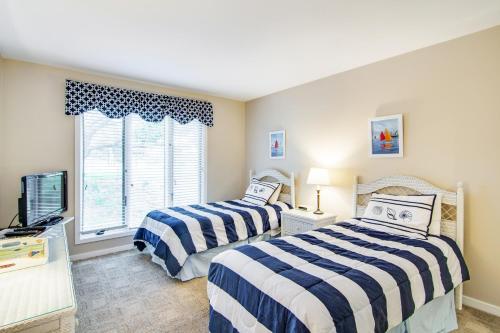 two beds in a room with a tv and a window at Fairway Dunes 3 in Isle of Palms