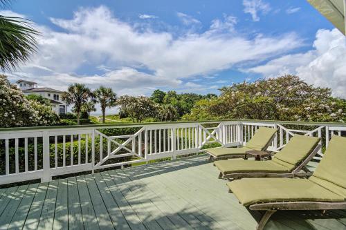 a balcony with chairs and a white fence at Flag Street 1851 A in Sullivans Island