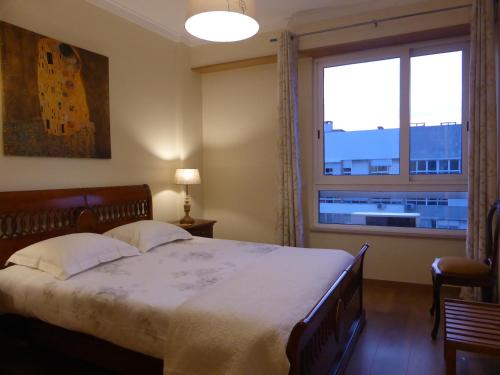 sypialnia z dużym łóżkiem i dużym oknem w obiekcie A View to the River Tejo - IBG HOME w Lizbonie