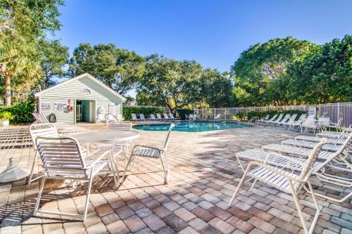 een terras met een tafel en stoelen naast een zwembad bij Pelican Bay 42 in Isle of Palms