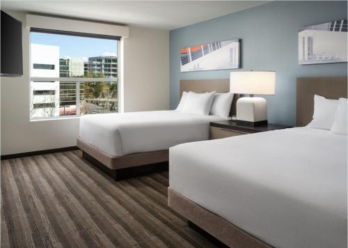 a hotel room with two beds and a window at Hyatt House San Jose Airport in San Jose
