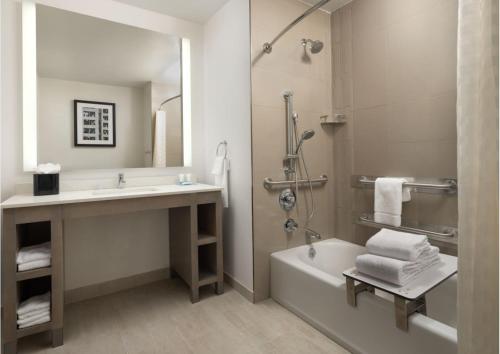 a bathroom with a sink and a tub and a shower at Hyatt House San Jose Airport in San Jose