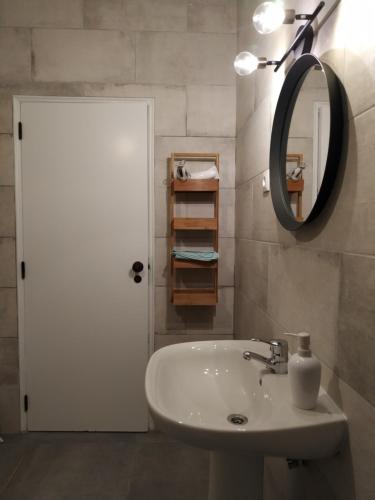 a bathroom with a white sink and a mirror at Tavira Lovers - City Centre Apartment III in Tavira