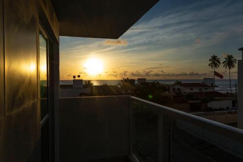 a view of the sunset from the balcony of a house at Pousada Maresia Unique Beira Mar in Porto De Galinhas