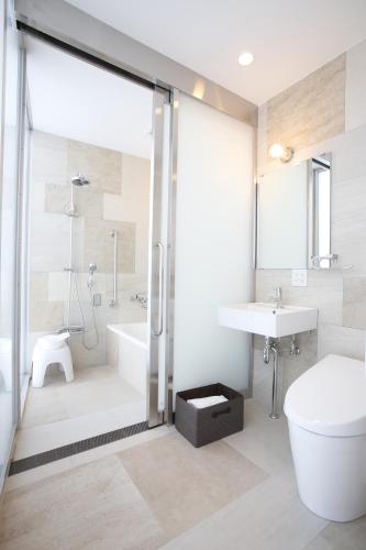 a bathroom with a shower and a toilet and a sink at 3 Wellness in Okayama