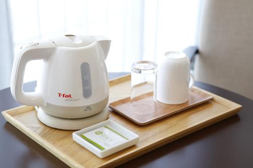 a mixer and a container of milk on a wooden tray at 3 Wellness in Okayama