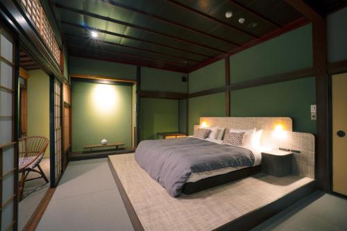 a bedroom with a large bed in a room at Bed and Craft MITU in Nanto