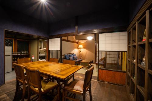 a dining room with a wooden table and chairs at Bed and Craft KIN-NAKA in Inami