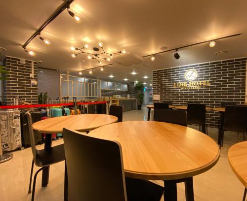 a restaurant with wooden tables and chairs and a brick wall at Line Hotel Myeongdong in Seoul