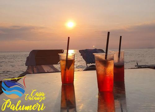 two drinks sitting on a table near the ocean at Casa I Sogni In Terrazzo in Marzamemi
