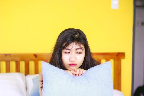 a woman is peeking out from behind a pillow at Sunbay Homestay Cu Lao Cham in Tân Hiệp