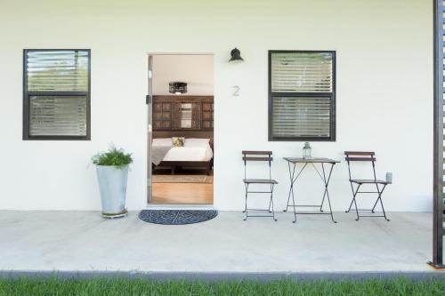 a patio with chairs and a table and a bedroom at Hotel Flora and Fauna in Wimberley