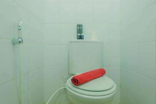 a red towel is sitting on a toilet in a bathroom at New Furnished Studio Apartment at Gunung Putri Square By Travelio in Bogor