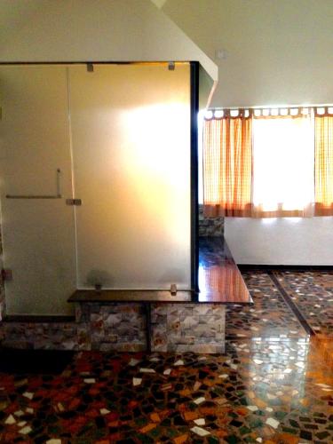 a room with a large window and a stone floor at Anandvan Holiday Homes, Wai in Wai