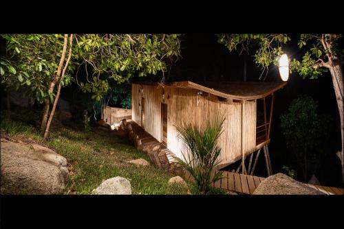 a small wooden building in a yard at night at Ecotao Lodge in Koh Tao