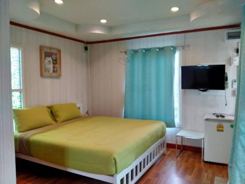 Dormitorio pequeño con cama y TV en บ้านปลายฝัน Baanplaifun, en Ban Huai Phai