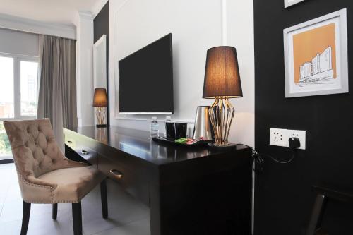 a desk with a lamp and a chair in a room at Queenco Hotel & Casino in Sihanoukville