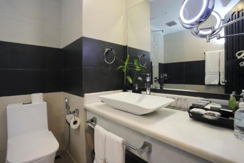 a bathroom with a sink and a mirror at Queenco Hotel & Casino in Sihanoukville