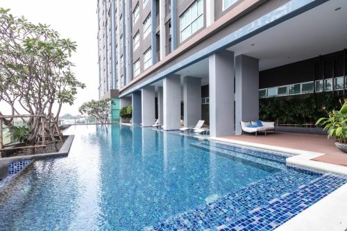 a swimming pool in a hotel with a building at Baan Kiang Fah Hua Hin 23-386 in Hua Hin