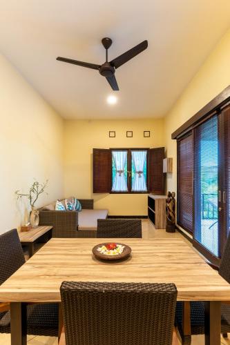 a dining room with a table and a ceiling fan at Benian Villas in Nusa Dua