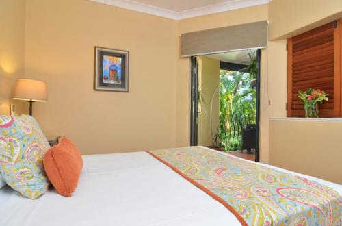 a bedroom with a large bed and a large window at Villa San Michele (Official) in Port Douglas