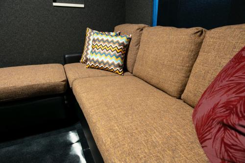 a brown couch with a pillow on top of it at GRAND BASE Takamatsu in Takamatsu