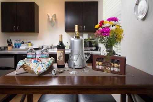 a table with bottles of wine and a vase of flowers at Hotel Flora and Fauna in Wimberley