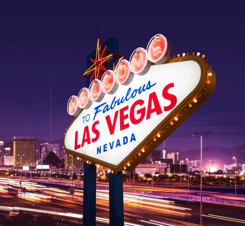 a sign for las vegas with a city in the background at Bposhtels Las Vegas in Las Vegas
